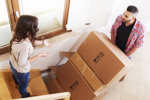 Local removal helper handling furniture delivery in Deptford